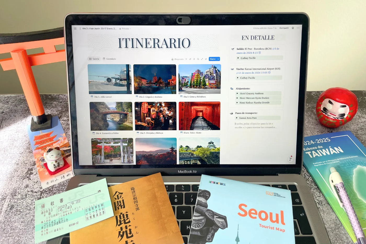 Ordenador con aplicación de viaje e itinerario personalizado a Japón por Oasia Viajes. En la pantalla se ven folletos para viaje a Seúl y Taiwán.