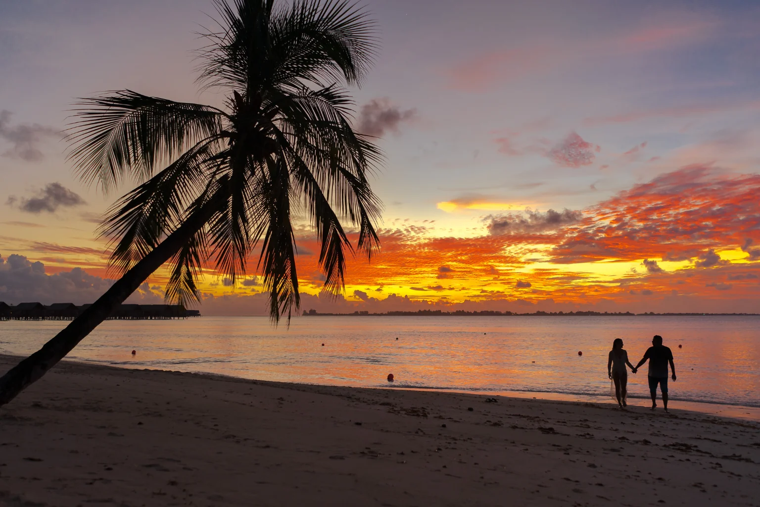 Pareja en playa de Maldivas en su viaje de luna de miel personalizada.